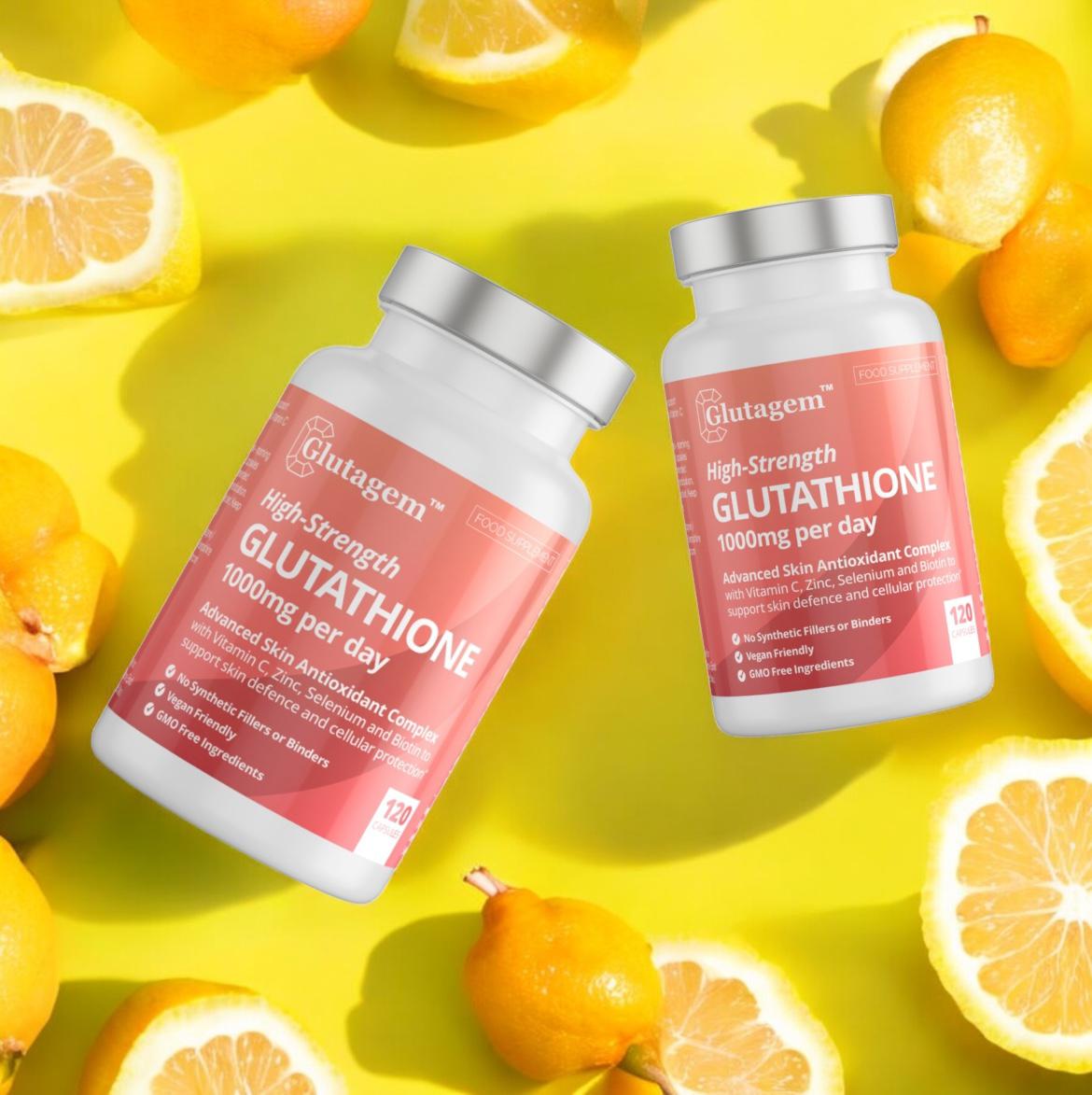 Two tubs of Glutagen High-Strength Glutathione supplement surrounded by sliced oranges on a yellow background.